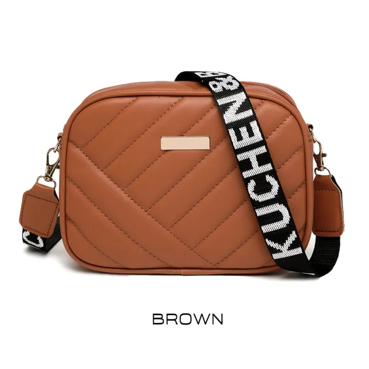 Brown quilted handbag with a black and white strap on a white background