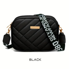 Black quilted handbag with a branded strap on a white background