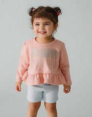 Child wearing a pink sweatshirt with a graphic design on a plain background