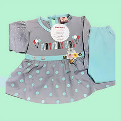 Children's dress with polka dots and 'Birthday Girl' text on a light green background