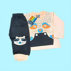 Children's outfit with black pants and peach shirt featuring raccoon designs on a light blue background