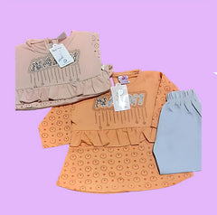 Three pieces of children's clothing on a purple background